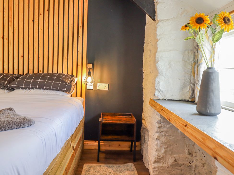 A bedroom with a bed and a nightstand at The Romantic Hideaway at Rhiw Goch Inn, Snowdonia National Park