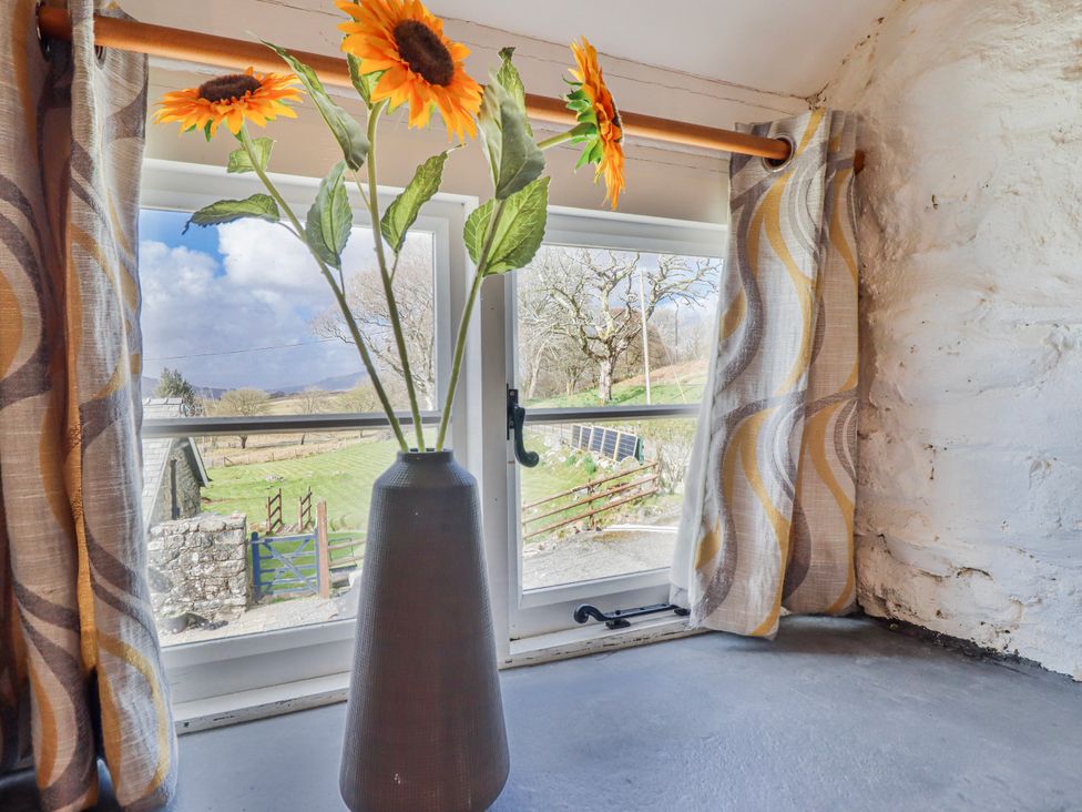 A window with sunflowers in a vase at The Romantic Hideaway at Rhiw Goch Inn Snowdonia National Park