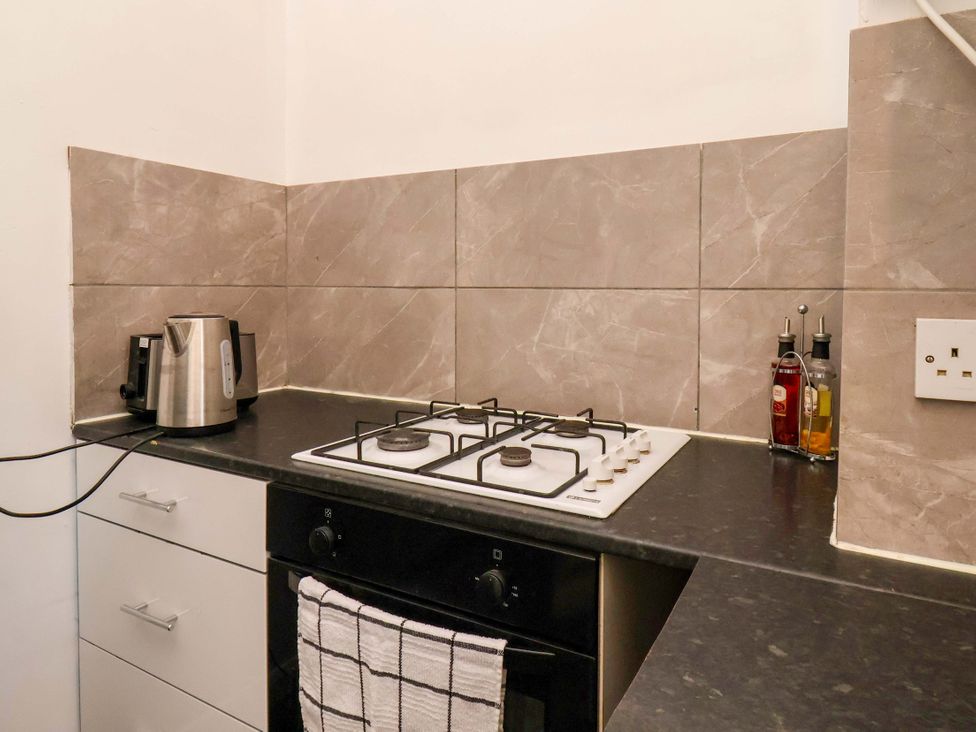 A kitchen with a gas stove, kettle, and oil dispensers at 122B Norton Road Stockton-on-Tees