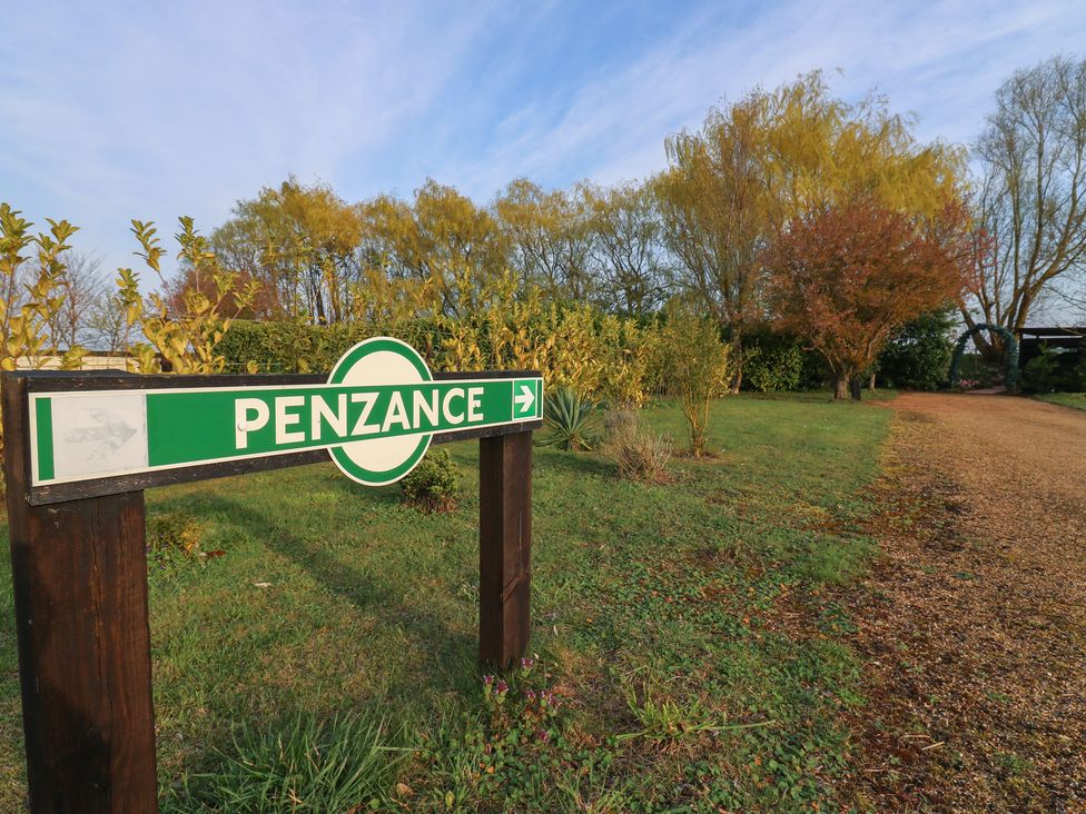 A directional sign pointing to Penzance in the outdoor area of Penzance Railway Carriage 1 with hot tub Ely