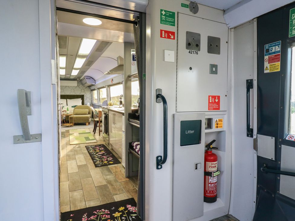 A view into a living area and kitchen at Penzance Railway Carriage 1 with hot tub in Ely