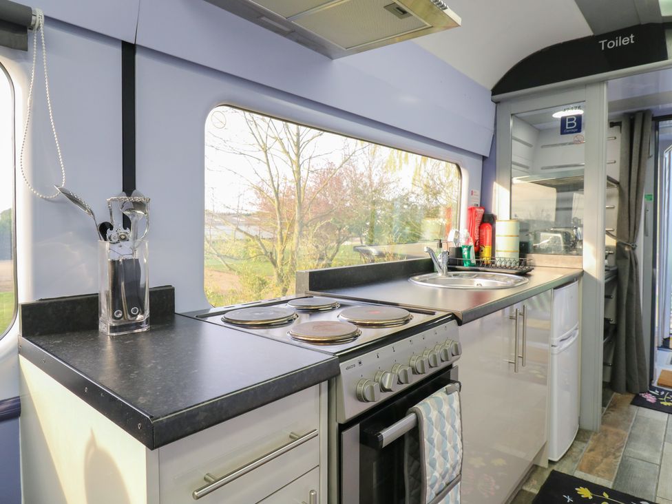 A kitchen with a sink and cooker at Penzance Railway Carriage 1 with hot tub in Ely