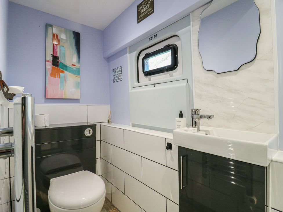 A bathroom with sink and toilet at Penzance Railway Carriage 1 with hot tub in Ely