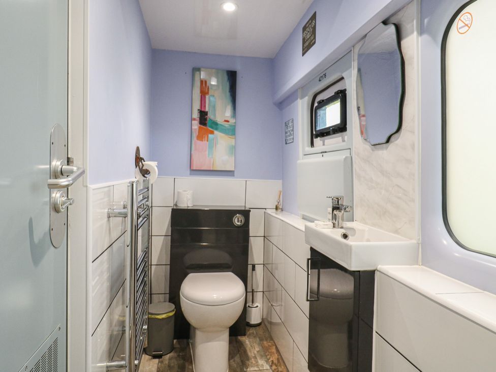 A bathroom with a toilet and sink at Penzance Railway Carriage 1 with hot tub, Ely