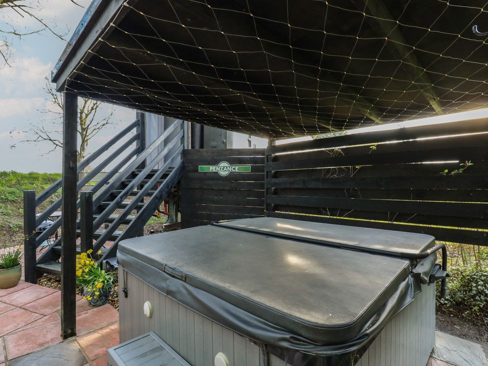 An outdoor area with a hot tub and stairs at Penzance Railway Carriage 1 with hot tub in Ely