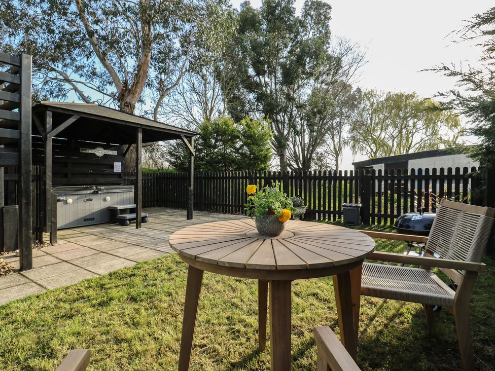 A garden with a table and chairs at Paddington Railway Carraige 2 with hot tub Ely