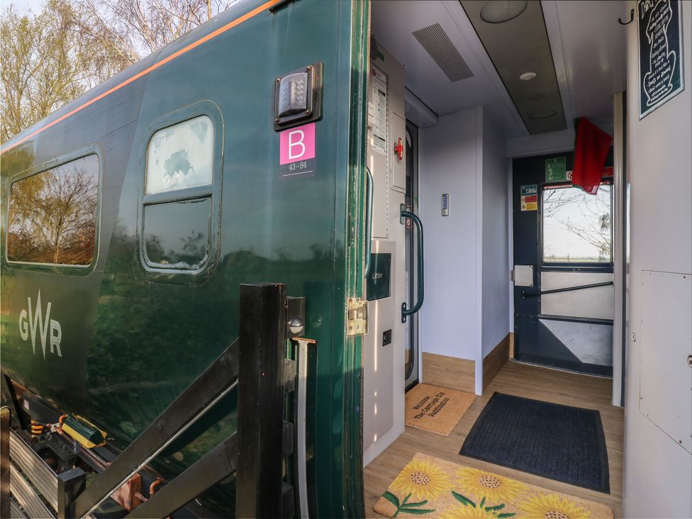An entrance of a train carriage with door and welcome mat at Paddington Railway Carraige 2 with hot tub in Ely