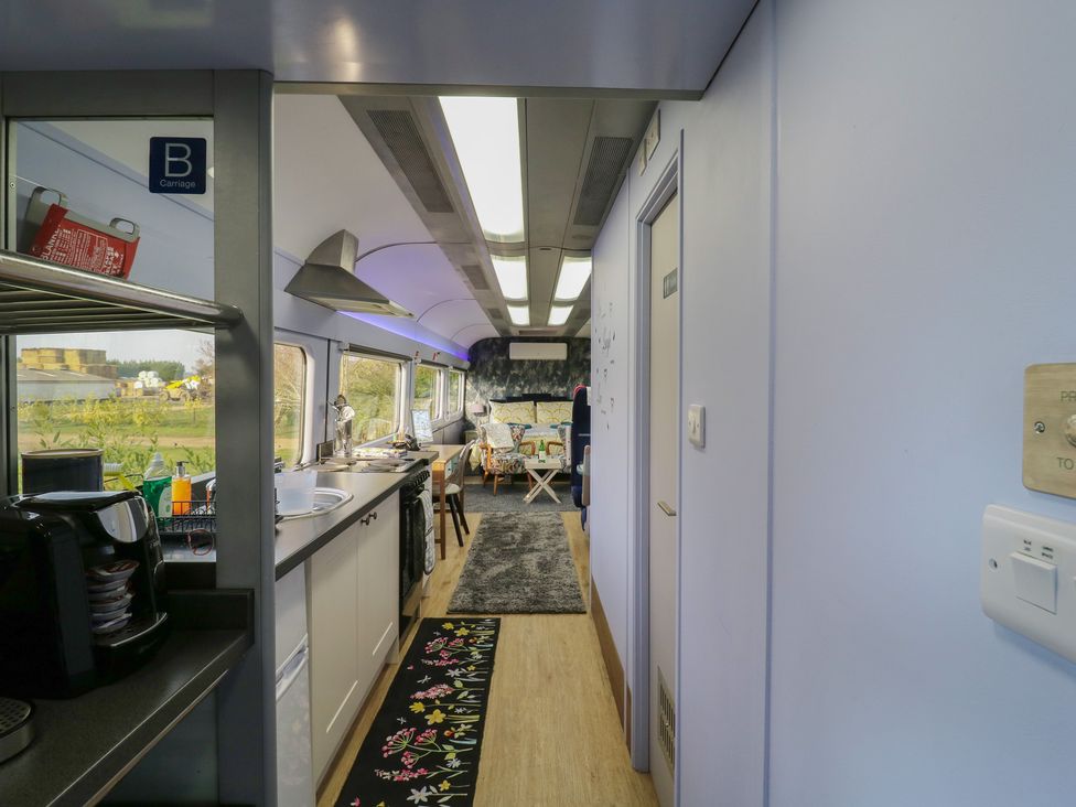 A kitchen area with a coffee maker and table at Paddington Railway Carraige 2 with hot tub, Ely