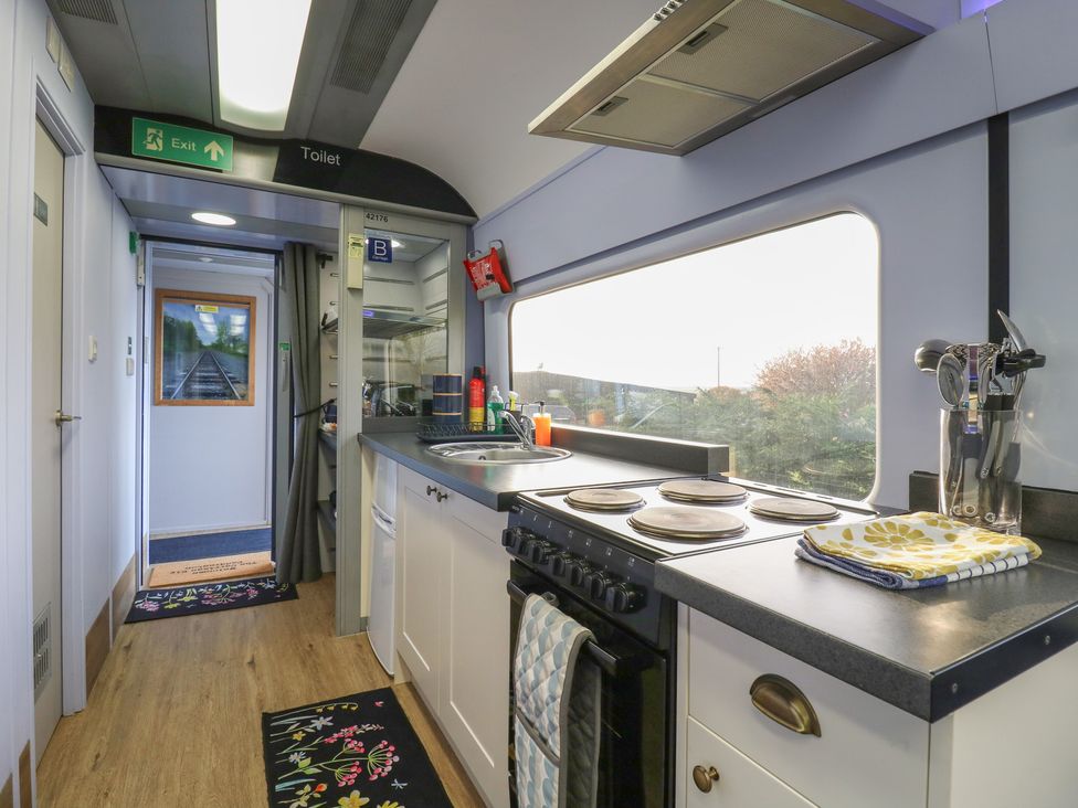 A kitchen with stove and sink at Paddington Railway Carraige 2 with hot tub in Ely