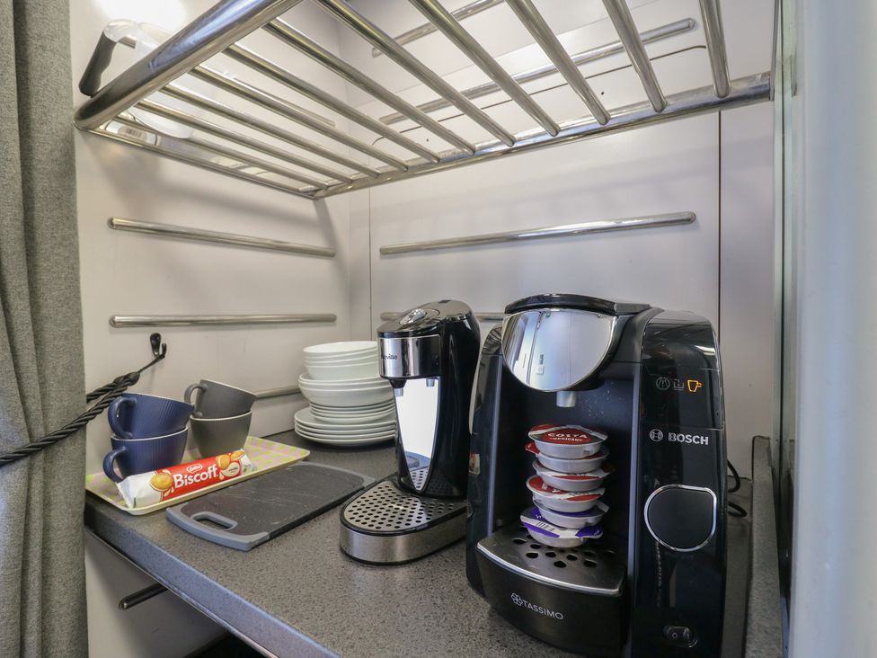 A coffee maker and dishes in a kitchen at Paddington Railway Carriage 2 with hot tub Ely