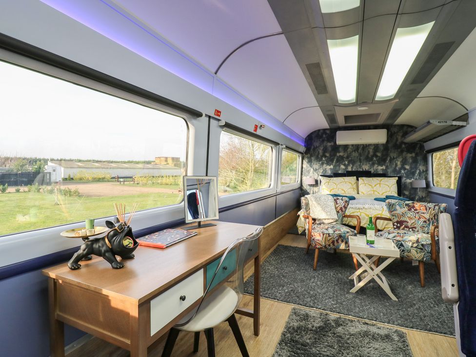 A living room with a desk and sofa at Paddington Railway Carriage 2 with hot tub, Ely