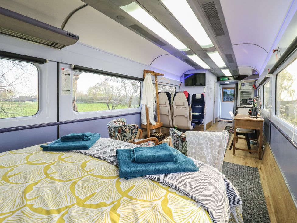 A living room with a bed and seating area at Paddington Railway Carraige 2 with hot tub, Ely