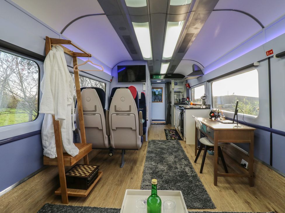 A railway carriage with seating and kitchen features at Paddington Railway Carraige 2 with hot tub in Ely