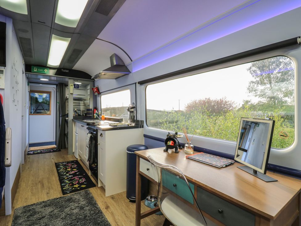A kitchen area with a desk and computer at Paddington Railway Carraige 2 with hot tub, Ely