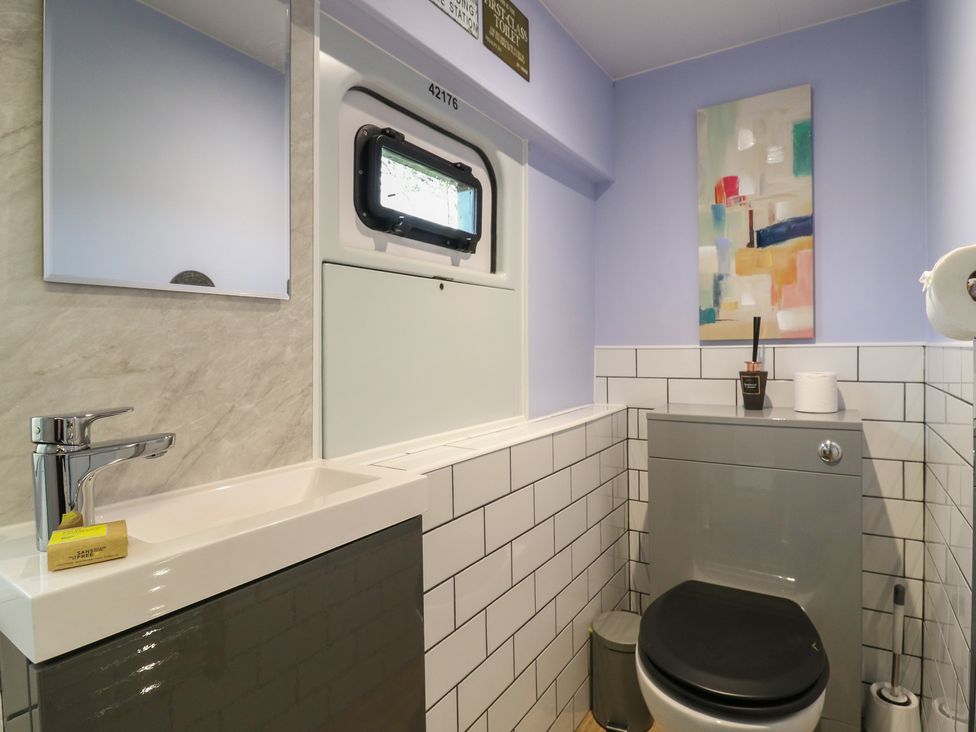 A bathroom with a sink and toilet at Paddington Railway Carraige 2 with hot tub, Ely
