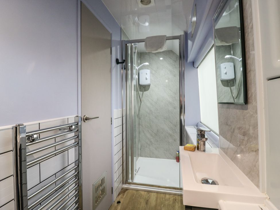 A bathroom with a shower and sink at Paddington Railway Carraige 2 with hot tub Ely