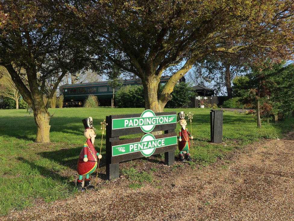 A sign reading Paddington Penzance with decorative figures at Paddington Railway Carraige 2 with hot tub Ely
