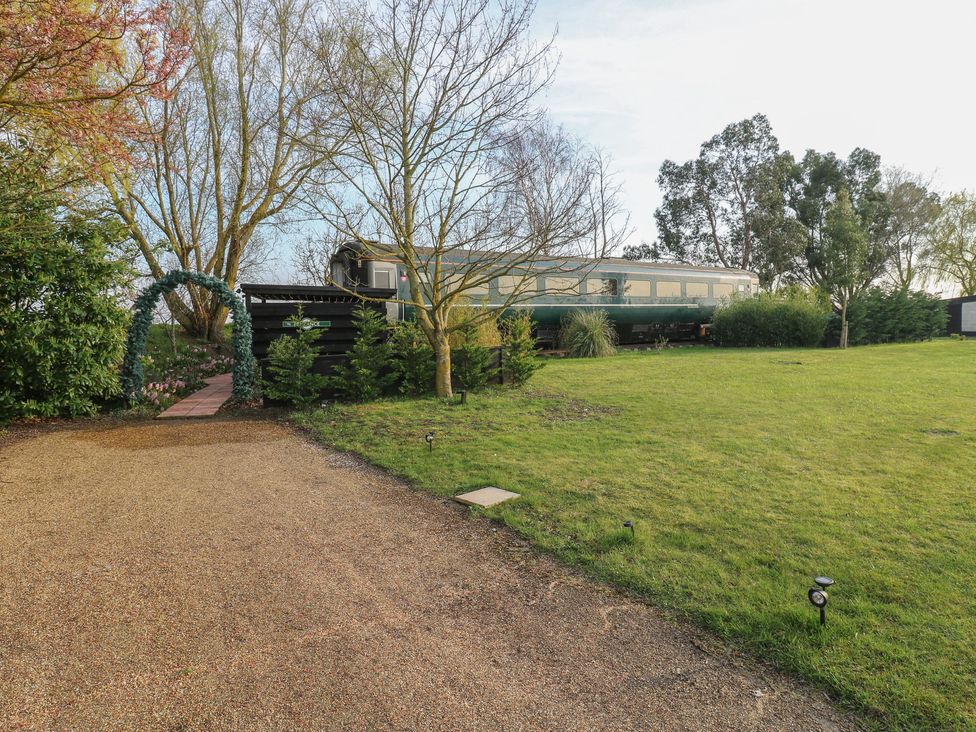 A garden with a pathway and a train carriage at Paddington Railway Carraige 2 with hot tub, Ely