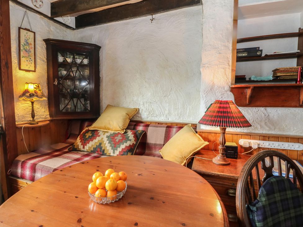 A dining room with a table and a cabinet at 4 Whiterow in Kentallen near Ballachulish