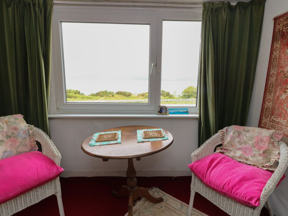 A snug with a table and chairs and a window at 4 Whiterow Kentallen near Ballachulish