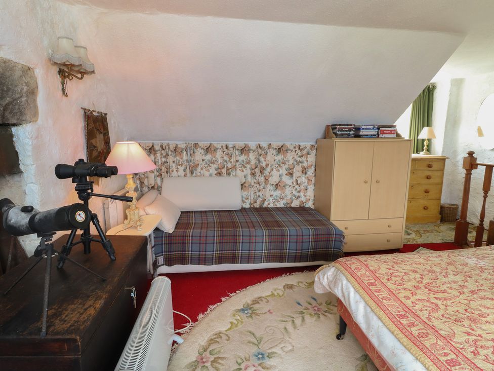 A bedroom with a bed, sofa, and telescope at 4 Whiterow in Kentallen near Ballachulish