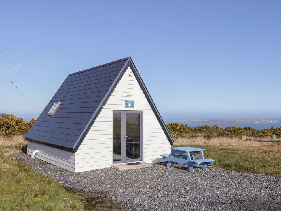 A cabin with a picnic table in front at Cabin 3 Cnoc na Naomh in Gortahawk