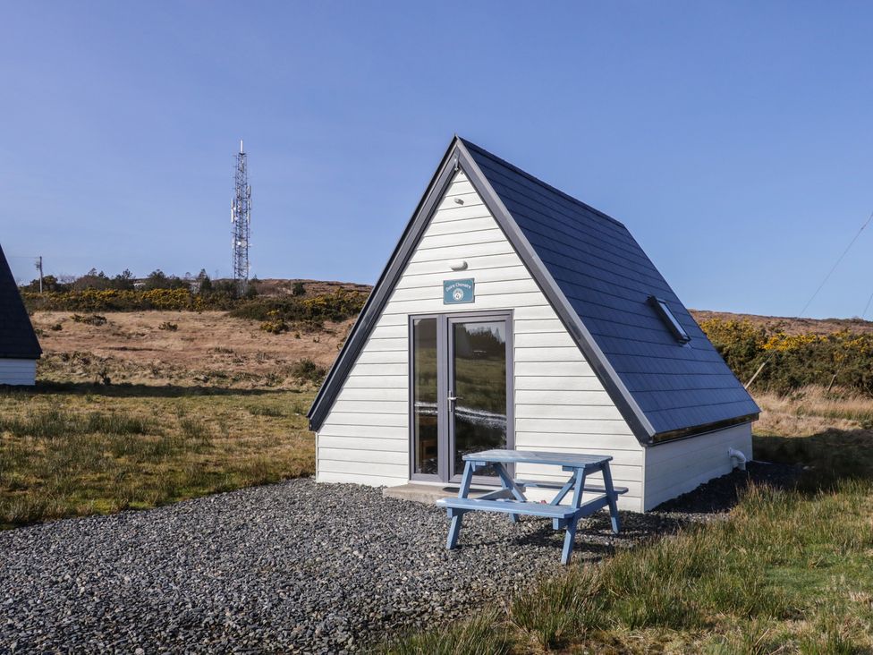 A cabin with a table and bench outside at Cabin 4 Doire Chonair in Gortahawk