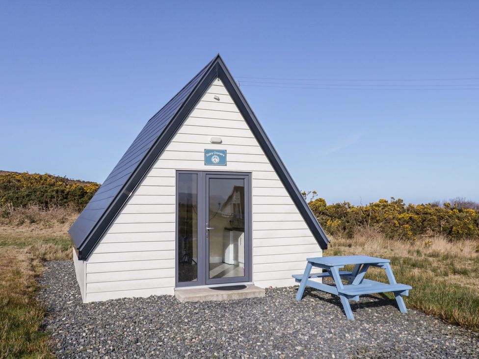 A cabin with a table and chairs outside at Cabin 4 Doire Chonair in Gortahawk
