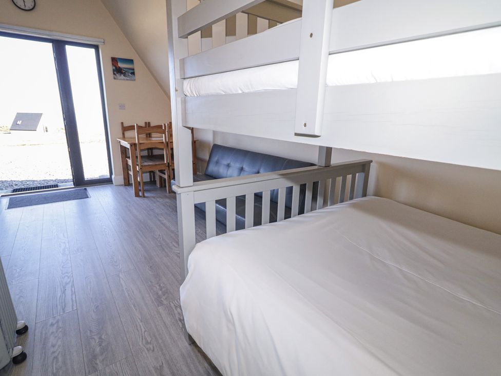 A bedroom with a bunk bed and a table at Cabin 4 Doire Chonair in Gortahawk