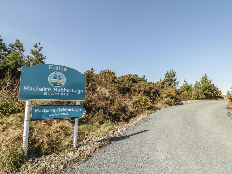 A sign indicating Machaire Rabhartaigh Glamping on a road in Gortahawk