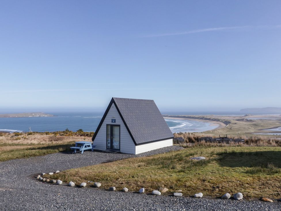 A cabin overlooking a lake and sea at Cabin 6 An Mhucais in Gortahawk