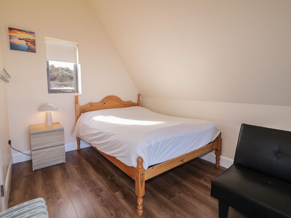 A bedroom with a bed and nightstand at Cabin 6 An Mhucais in Gortahawk