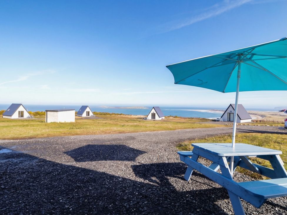 An outdoor area with a table and umbrella at Cabin 6 An Mhucais in Gortahawk