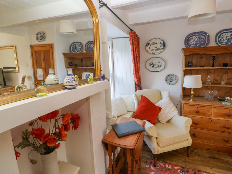 A living room with a table and chairs at St. Dominic Cottage in St. Ives