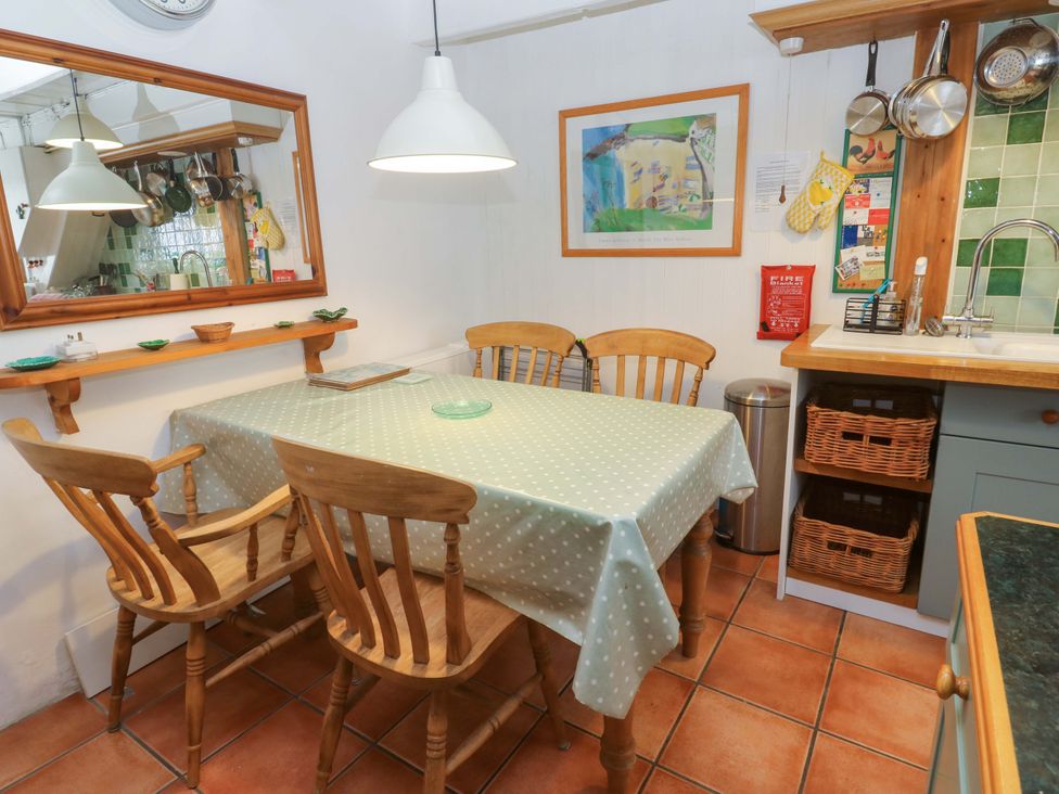 A dining room with a table and chairs at St. Dominic Cottage in St. Ives