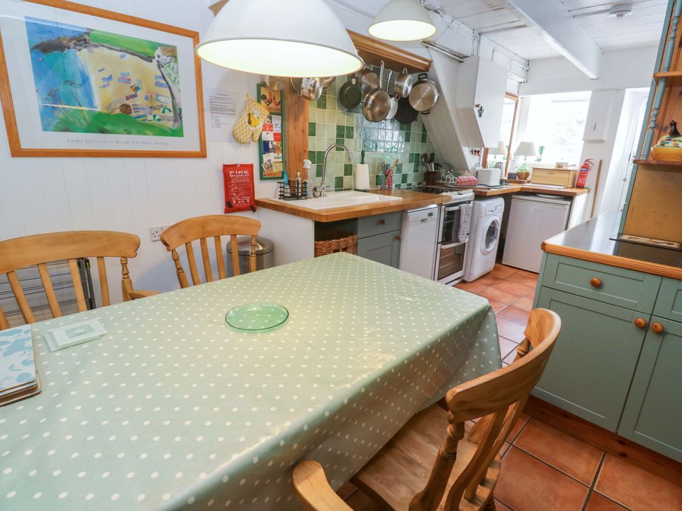 A kitchen with dining table and appliances at St. Dominic Cottage St. Ives