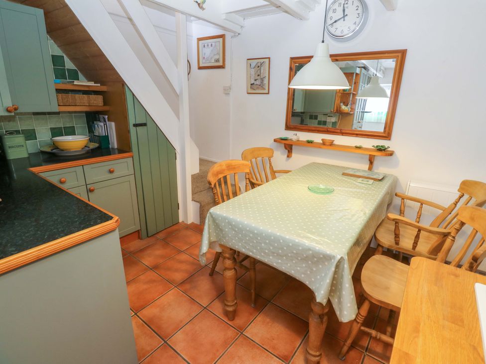 A dining room with a table and chairs at St. Dominic Cottage in St. Ives