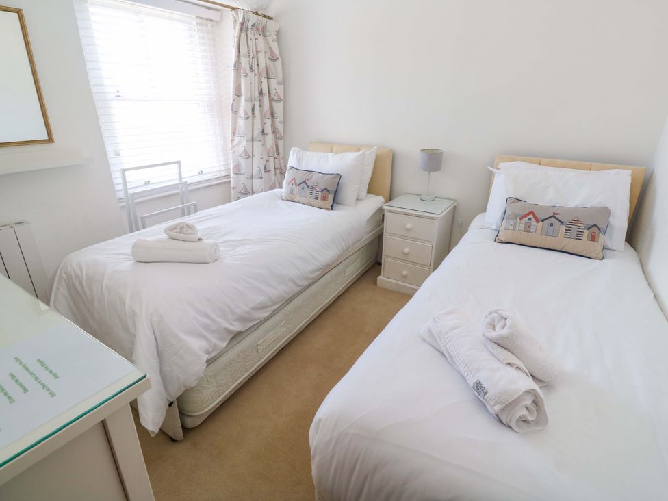 A bedroom with twin beds and a bedside table at St. Dominic Cottage in St. Ives