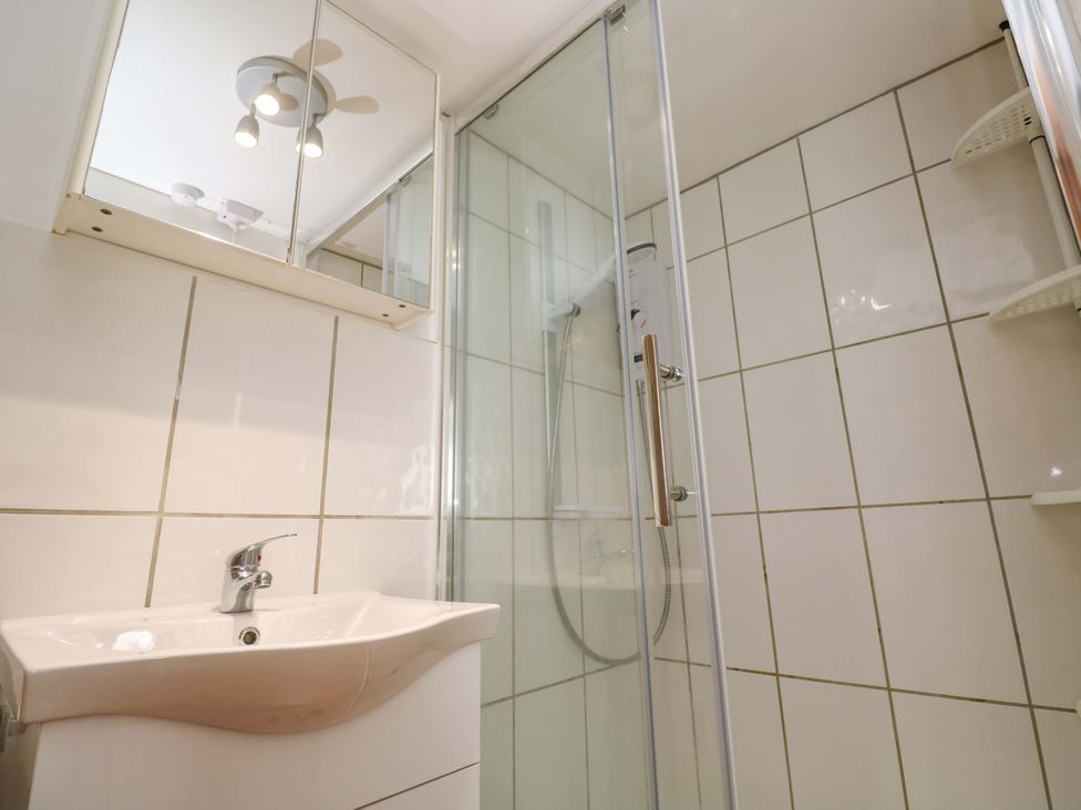 A bathroom with a sink and shower enclosure at St. Dominic Cottage St. Ives