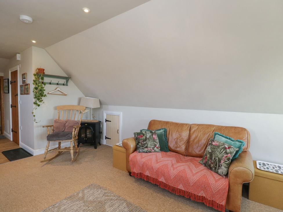 A living room with a sofa and rocking chair at The Hideaway Loft in Chippenham