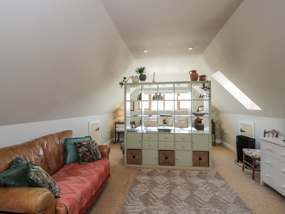 A living room with a sofa and storage unit at The Hideaway Loft in Chippenham
