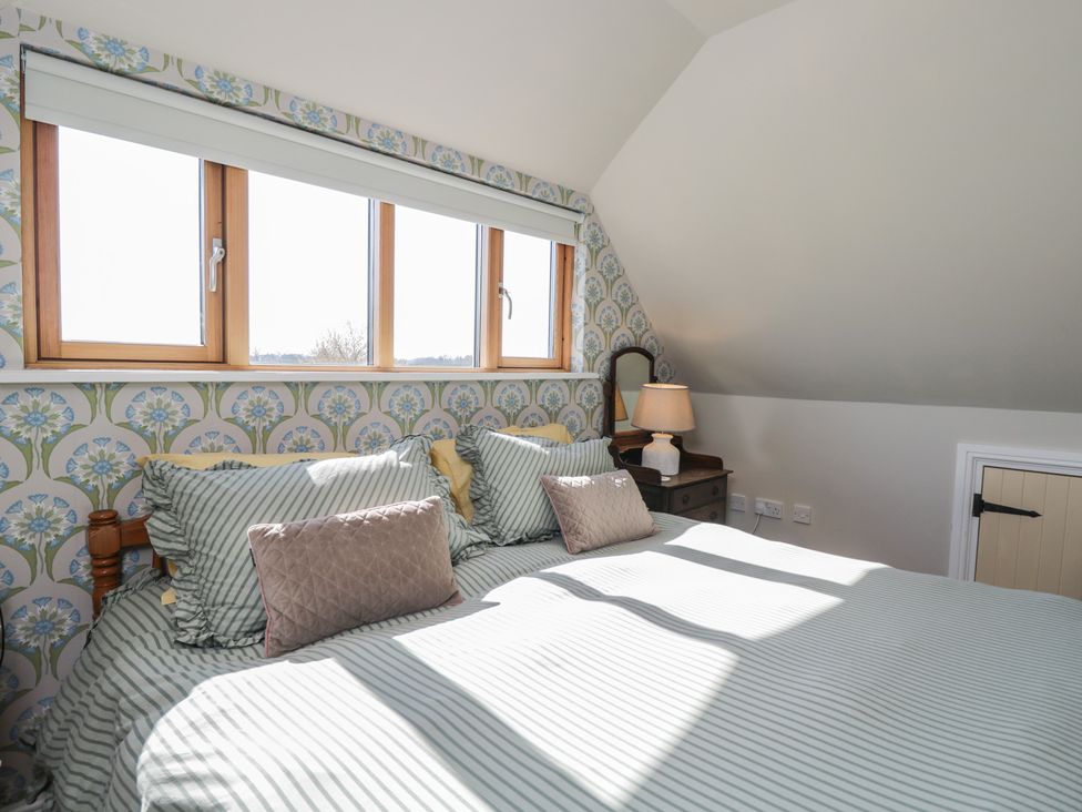 A bedroom with a bed and lamp at The Hideaway Loft in Chippenham