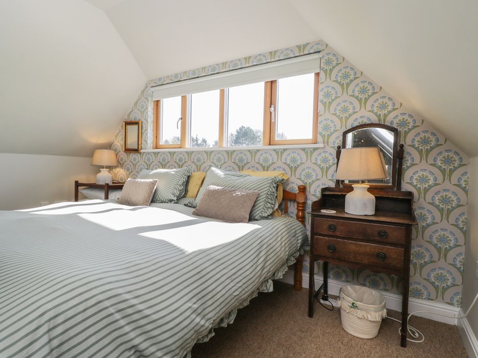 A bedroom with a bed and nightstand at The Hideaway Loft in Chippenham