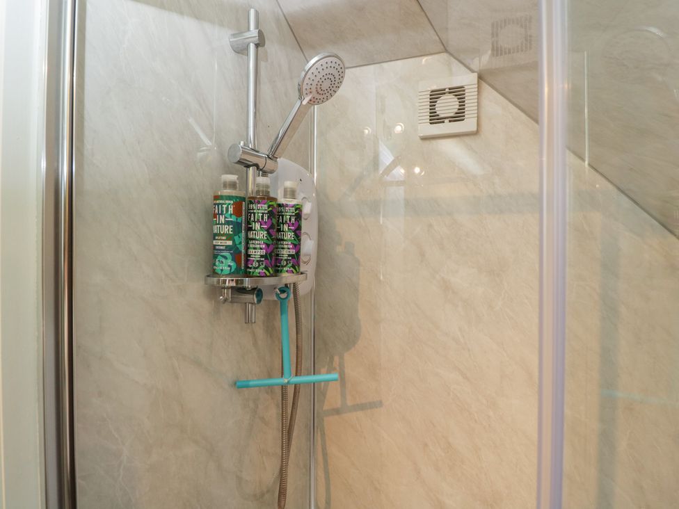 A shower with shampoo bottles and controls at The Hideaway Loft in Chippenham
