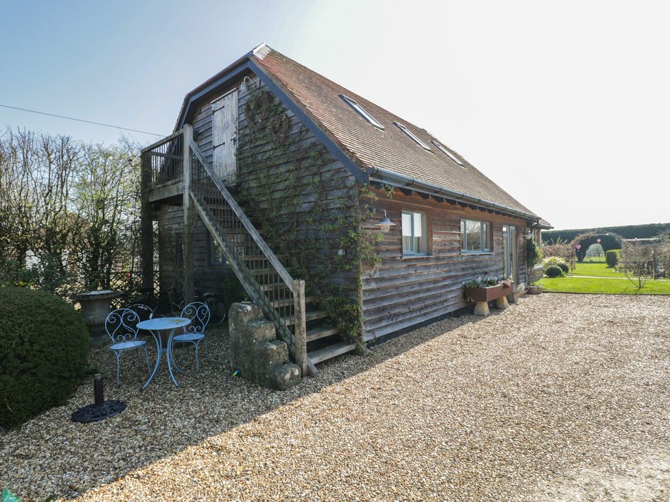 An outdoor area with a house, staircase, table, and chairs at The Hideaway Loft in Chippenham