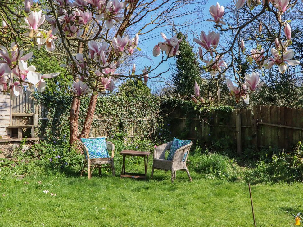 A garden with chairs and a table at Upper Frogpool Cottage in Crediton
