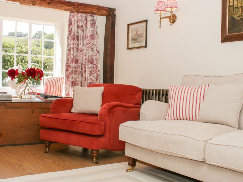 A living room with an armchair and a sofa at Upper Frogpool Cottage in Crediton