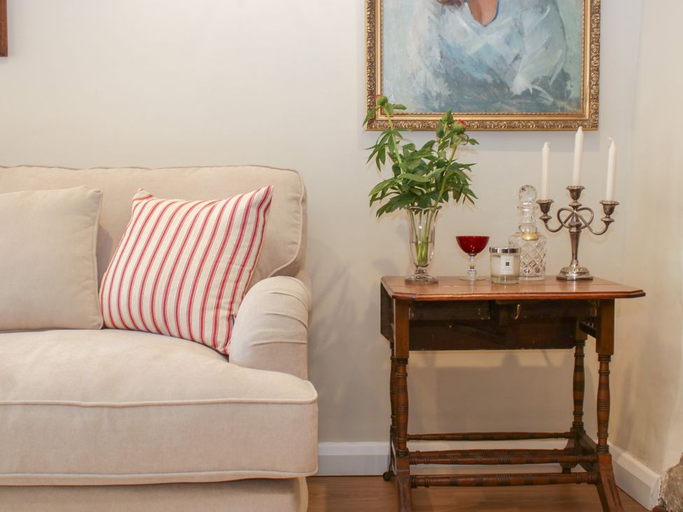 A living room with a sofa and a table at Upper Frogpool Cottage in Crediton