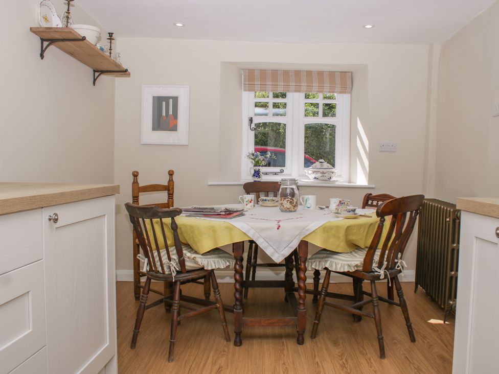 A dining room with a table and chairs at Upper Frogpool Cottage in Crediton
