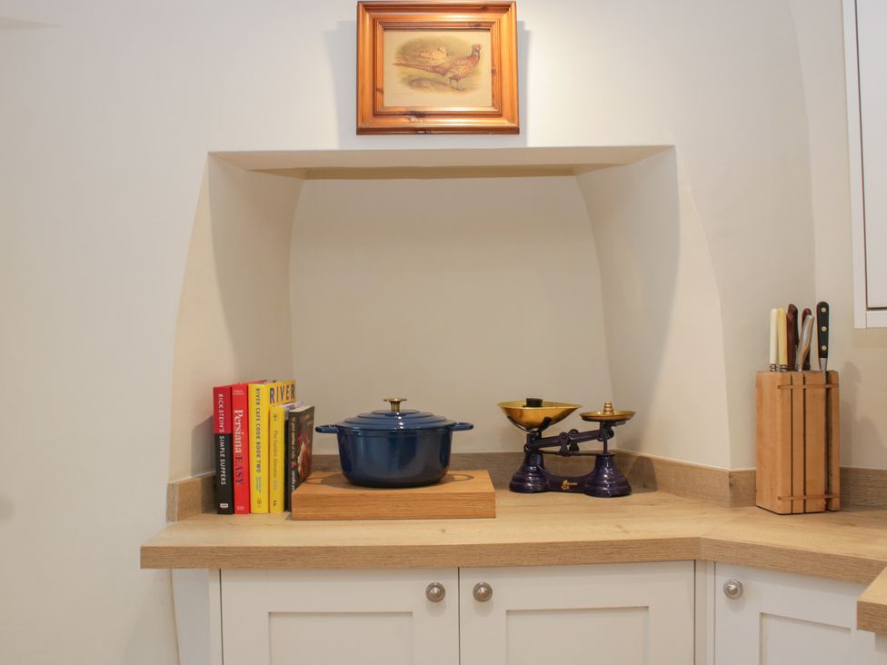 A kitchen area with a pot, scale, and books at Upper Frogpool Cottage in Crediton